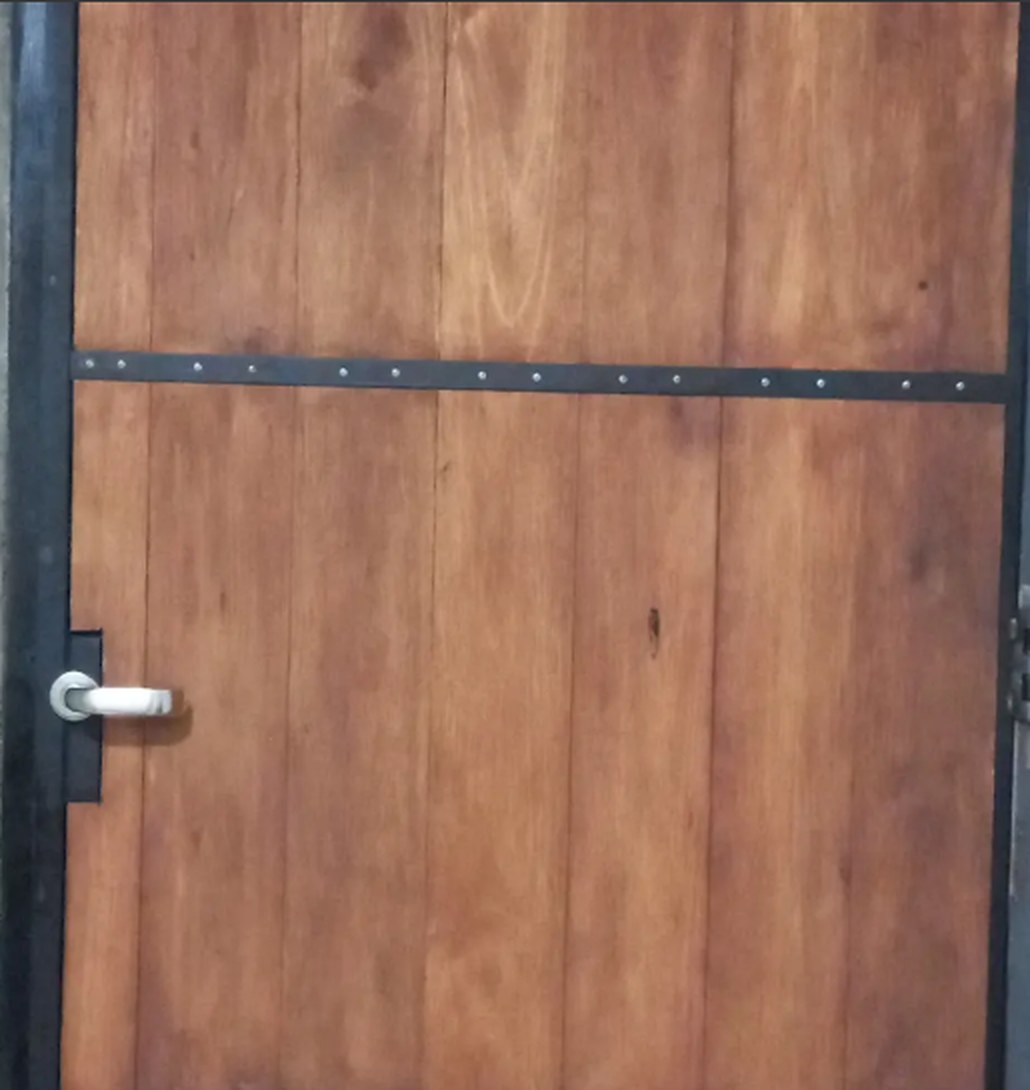 Puerta de madera con herrajes de hierro